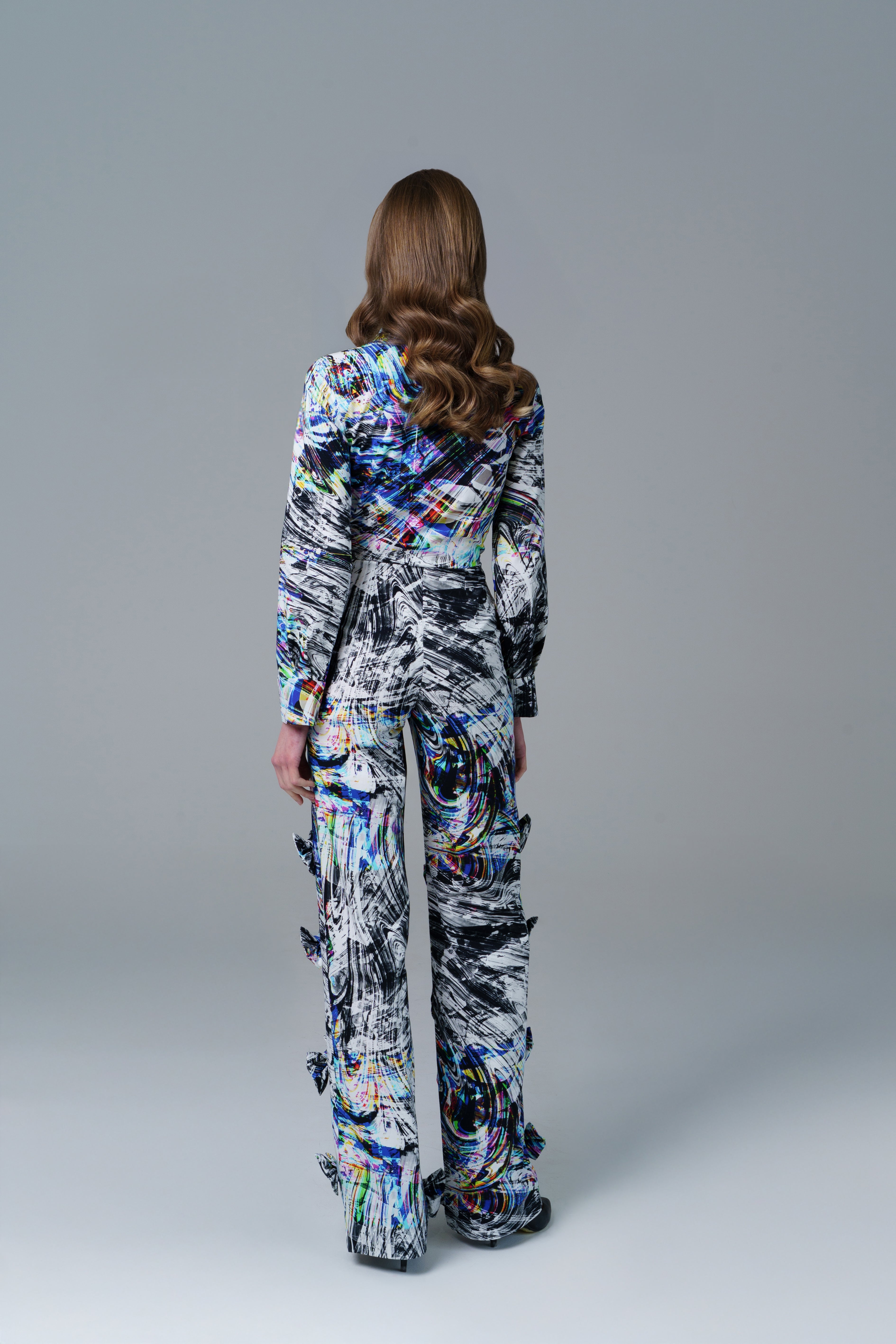 Bold abstract print top with front bow detail and structured fit. A modern, artistic statement piece.