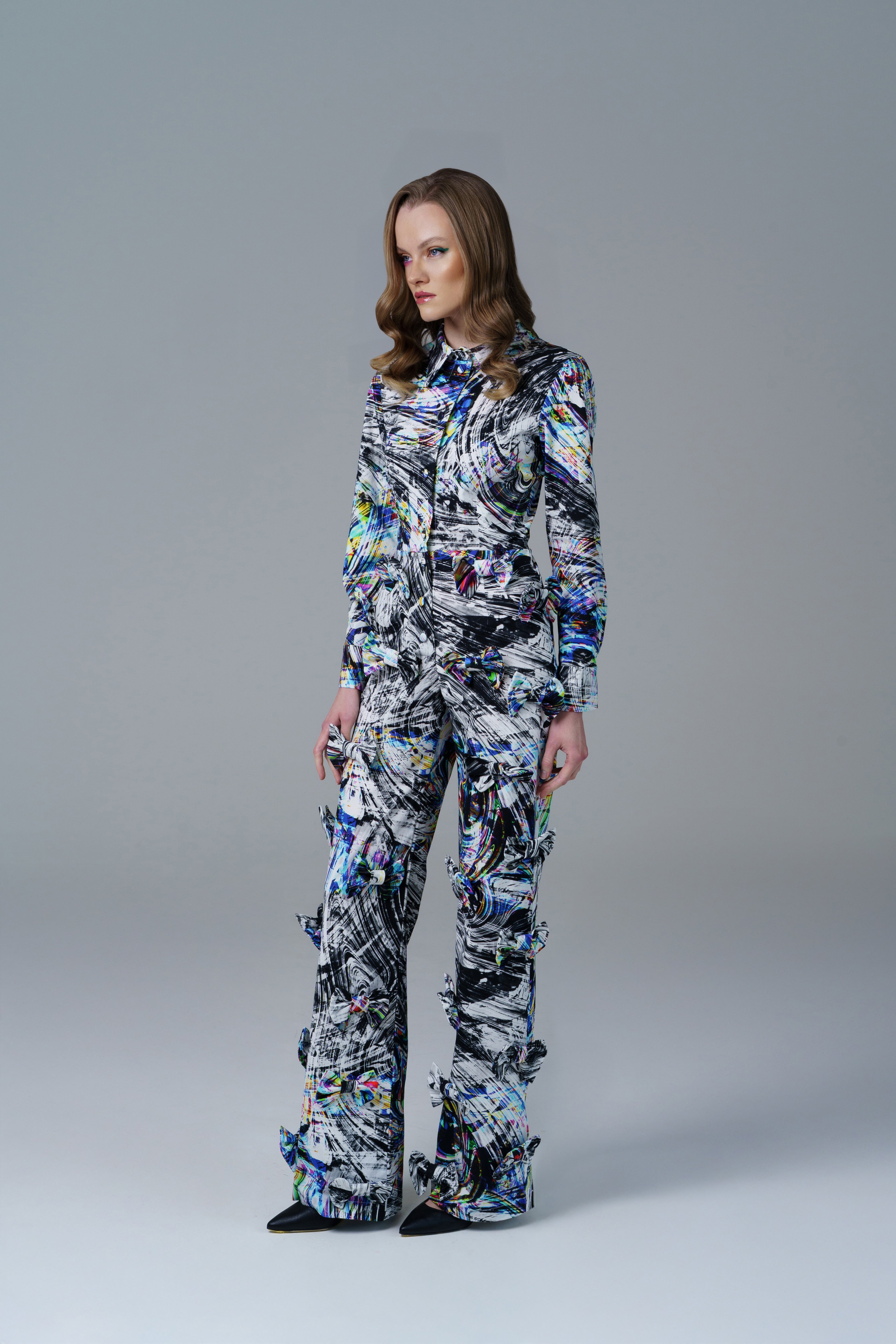 Bold abstract print top with front bow detail and structured fit. A modern, artistic statement piece.