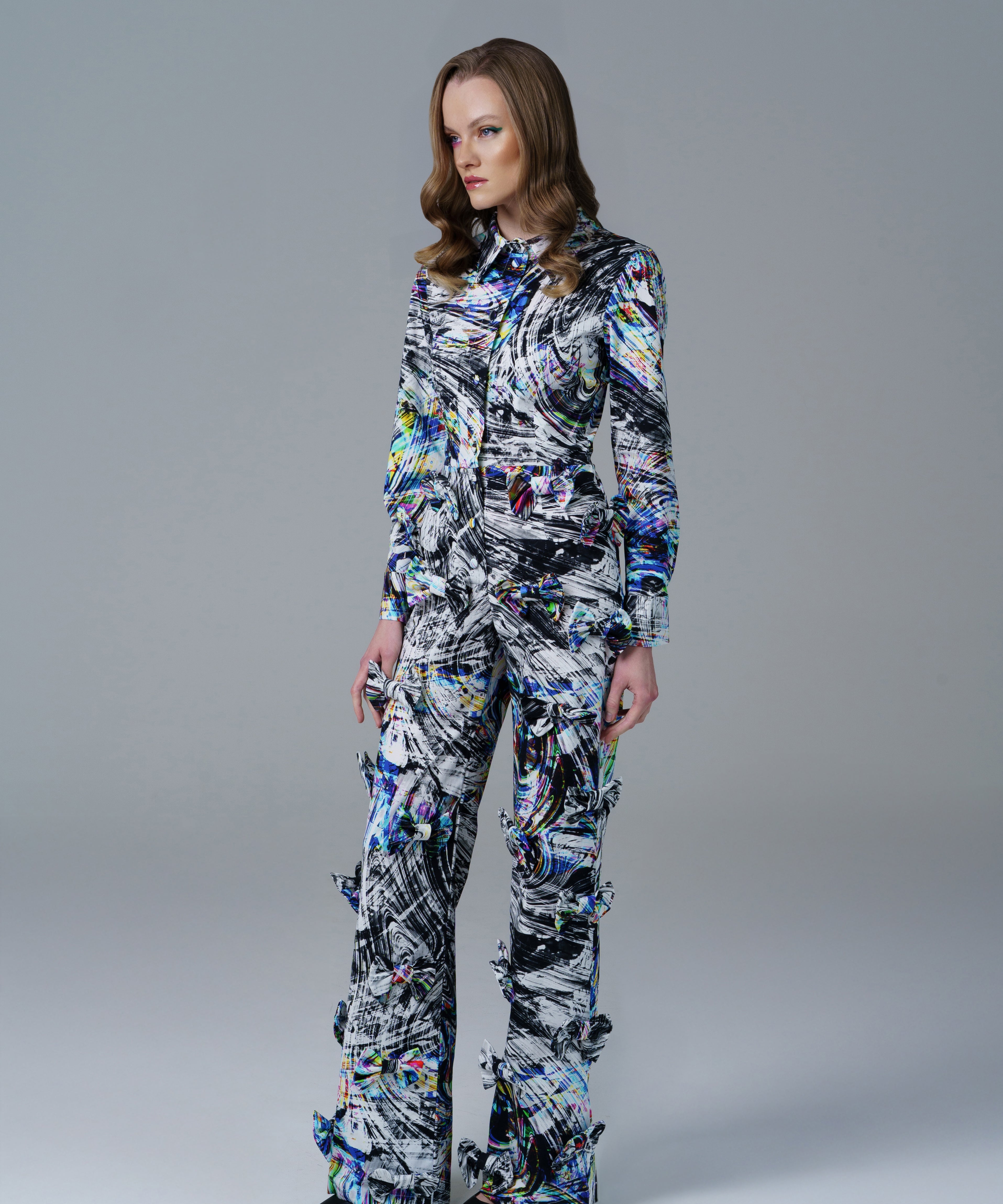 Bold abstract print top with front bow detail and structured fit. A modern, artistic statement piece. 